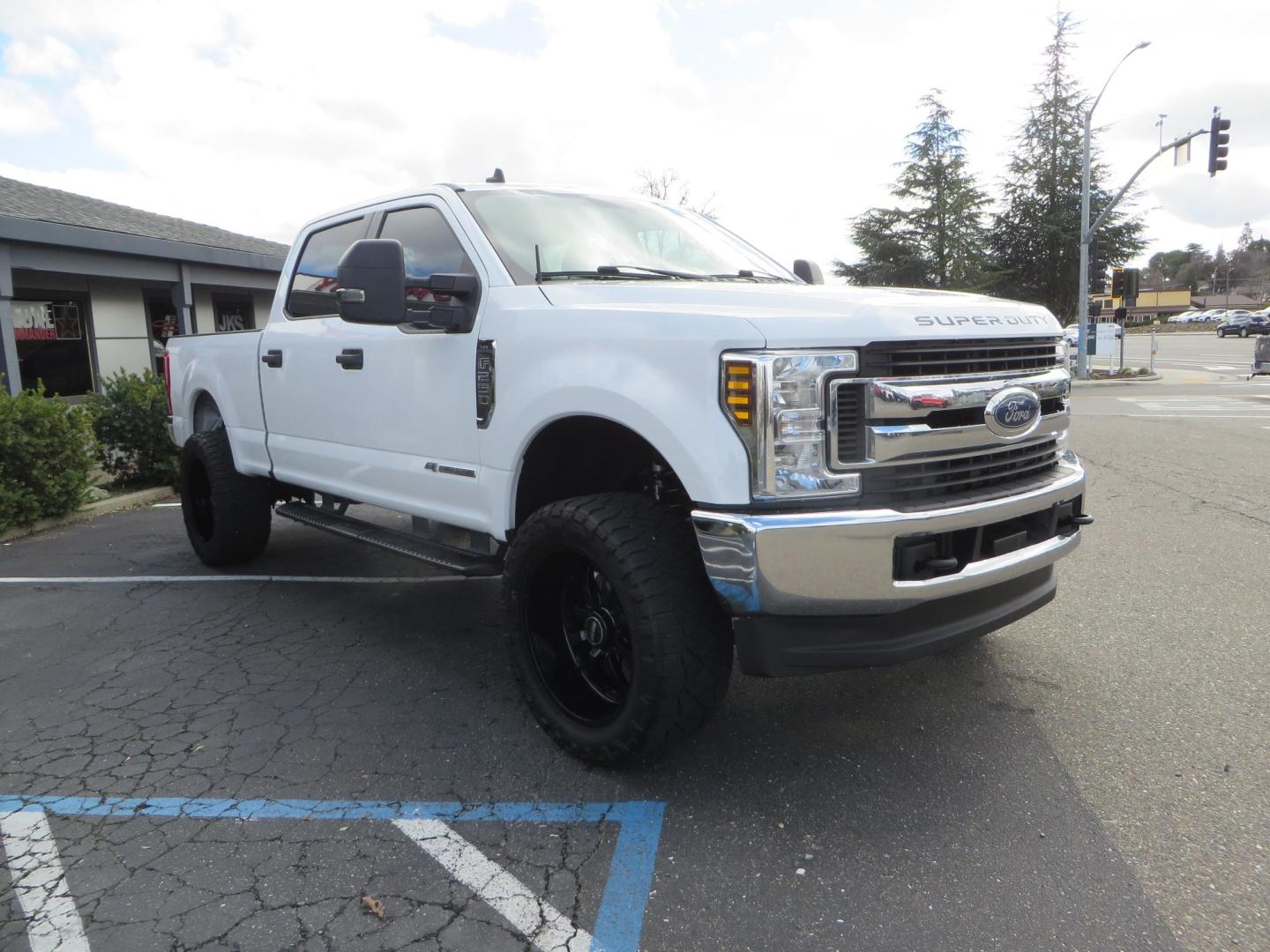 2019 White Ford F-250 SD XLT Crew Cab Short Bed 4WD (1FT7W2BT9KE) with an 6.7L V8 OHV 16V DIESEL engine, 6A transmission, located at 2630 Grass Valley Highway, Auburn, CA, 95603, (530) 508-5100, 38.937893, -121.095482 - Leveled XLT sitting on 22" SOTA Novakane wheels, 325 Nitto Ridge Grappler tires, Fox Shocks and dual steering stabilizers, Firestone Ride Rite air bags, Airlift wireless 1 air compressor, B and W Turnover gooseneck hitch, Weathertech floor liners, Deezee tailgate assist, and window tint. - Photo#2